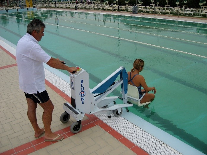Un maitre nageur assiste une personne à mobilité réduite dans sa mise à l'eau avec l'élévateur mobile piscine BluOne