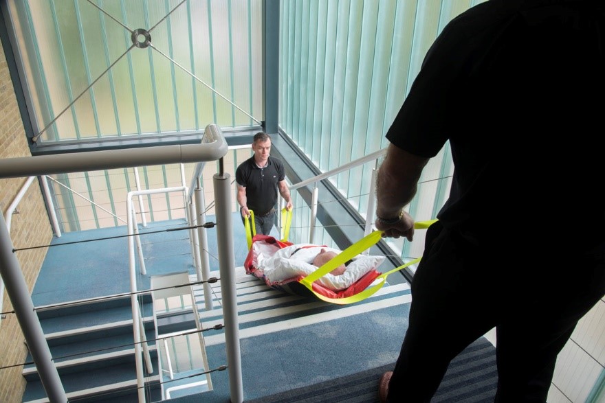 Deux secouriste utilise le matelas EvacPad pour évacuer, via les escaliers, une personne faisant un malaise dans une entreprise.