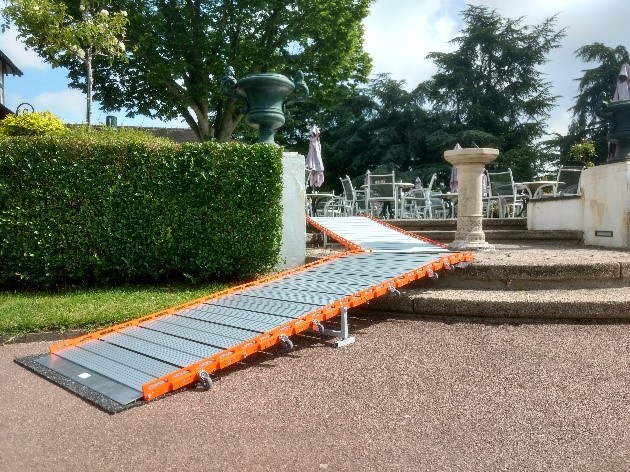 Une rampe d’accès PMR Roll Up en aluminium donne l'accès à la terrasse d'un golf