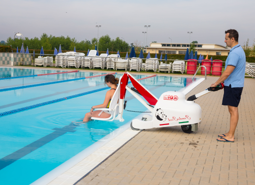 Un aidant permet à une personne à mobilité réduite d'accéder à une piscine grâce à un élévateur mobile PandaPool