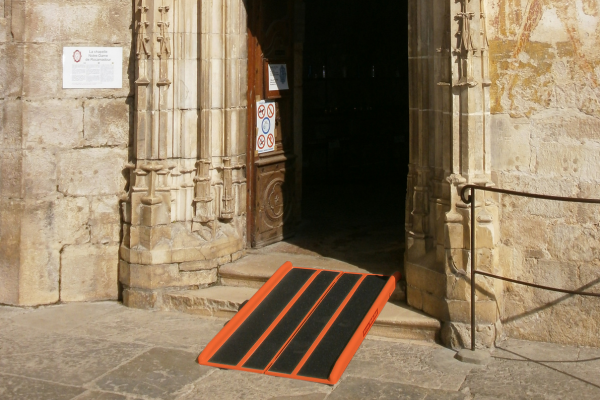 La rampe d'accès PMR Shop Ramp New est posée dvant l'entrée d'une église pour permettre aux personnes en fauteuil roulant d'entrer à l'intérieur.